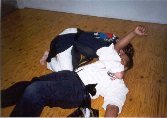 A08- Maintaining a hold on the neck and arm, he pulls himself to his knees at the opponents' side